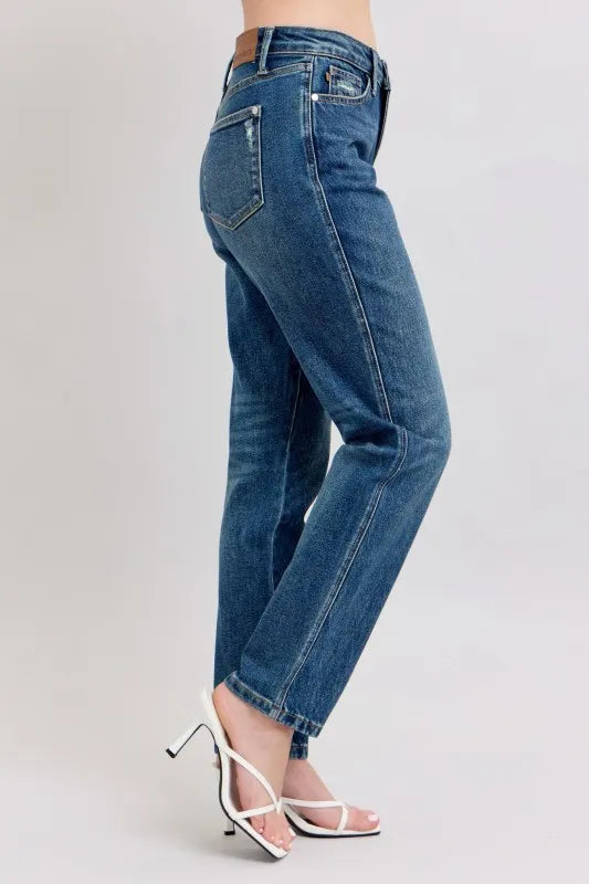 Blue jeans worn by a person on a light gray background