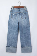 Blue jeans with cuffed hems on a white background