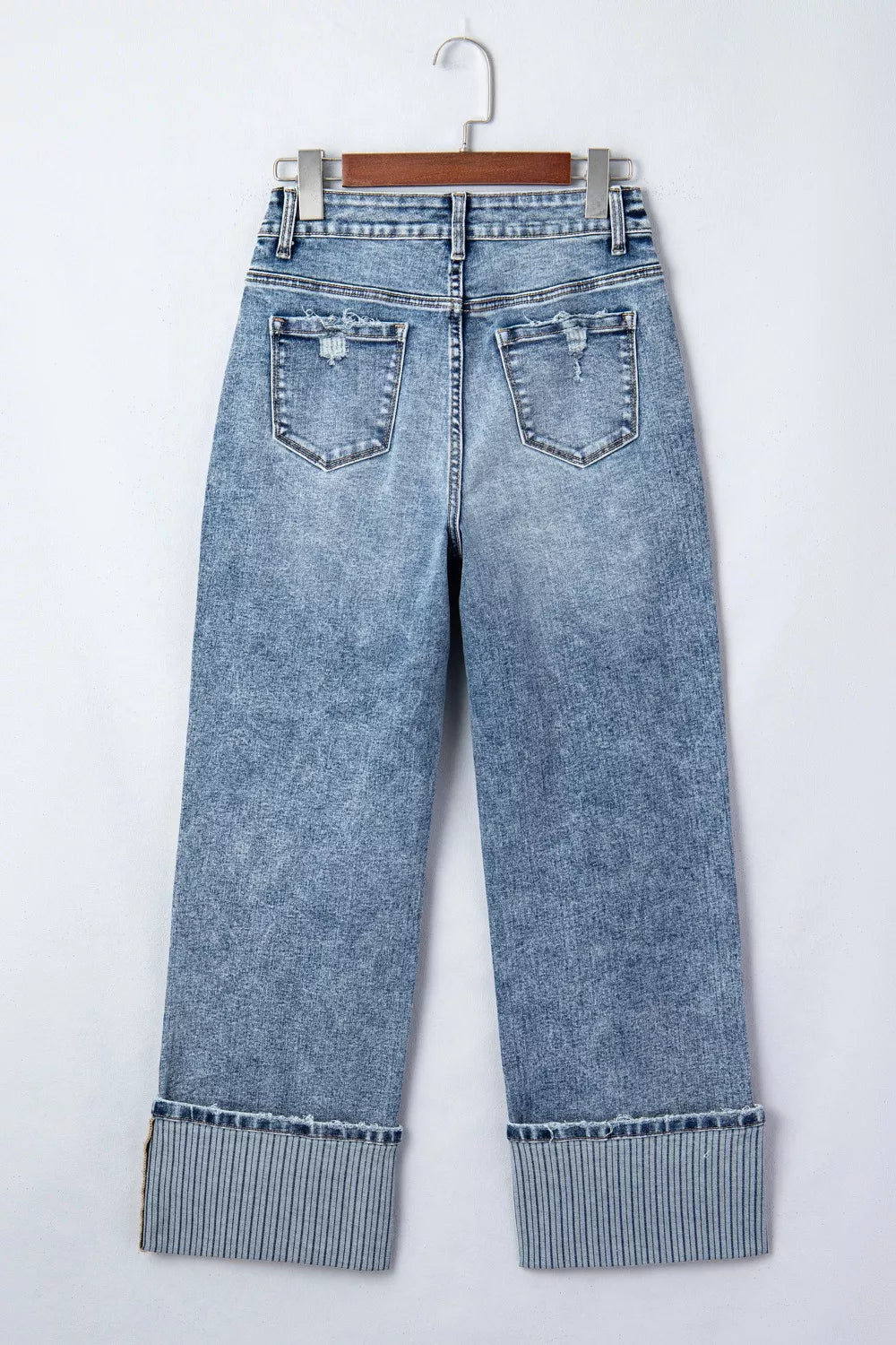 Blue jeans with cuffed hems on a white background