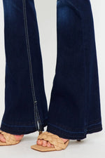 Navy blue jeans worn by a person on a white background