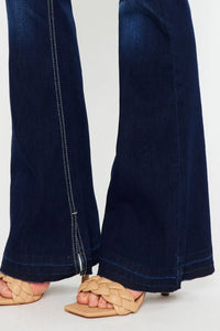 Navy blue jeans worn by a person on a white background