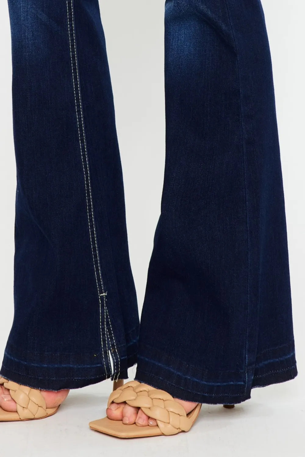 Navy blue jeans worn by a person on a white background