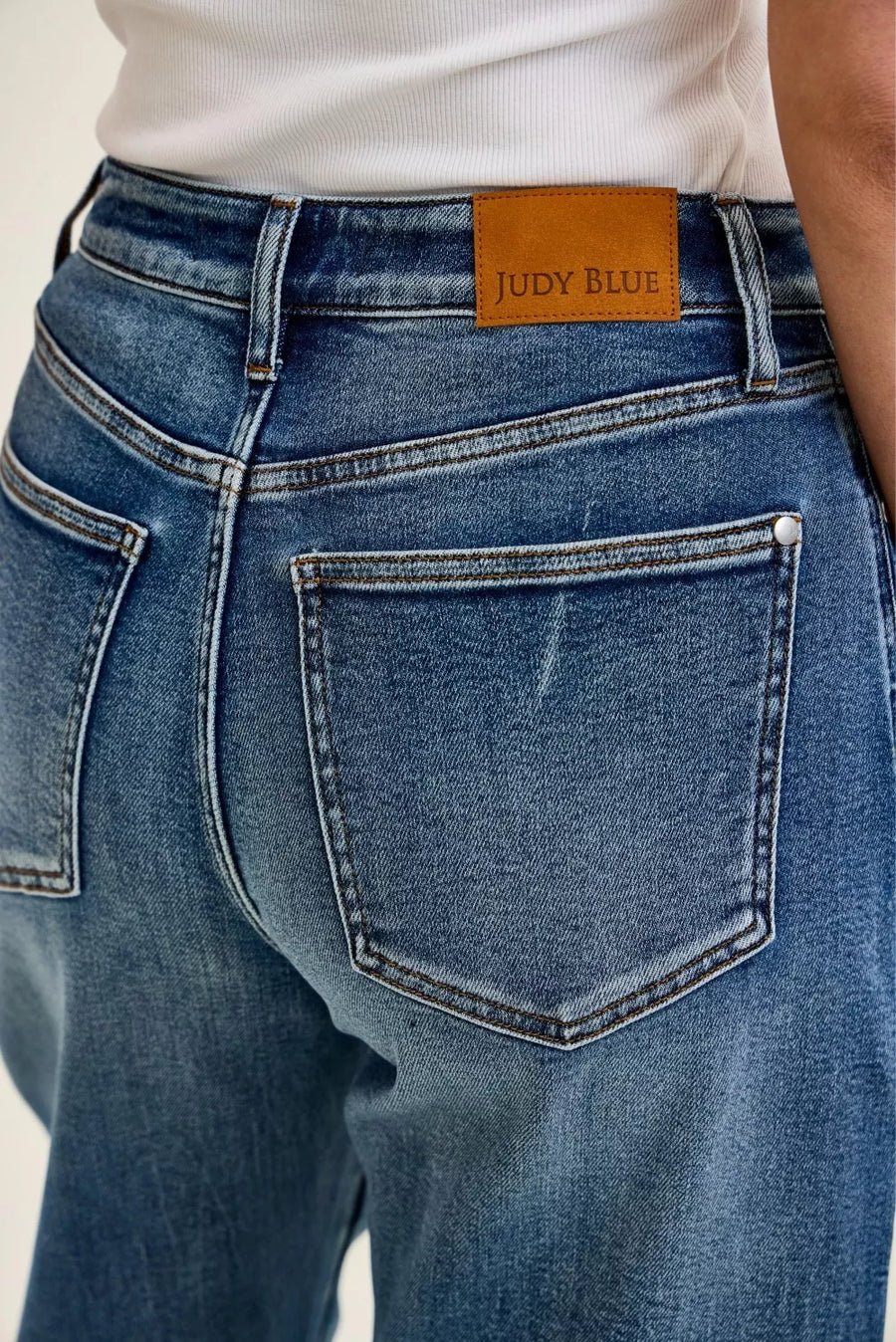 Close-up of blue jeans with a Judy Blue label on the back pocket.