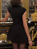 Person wearing a black dress in an ornate room with gold accents