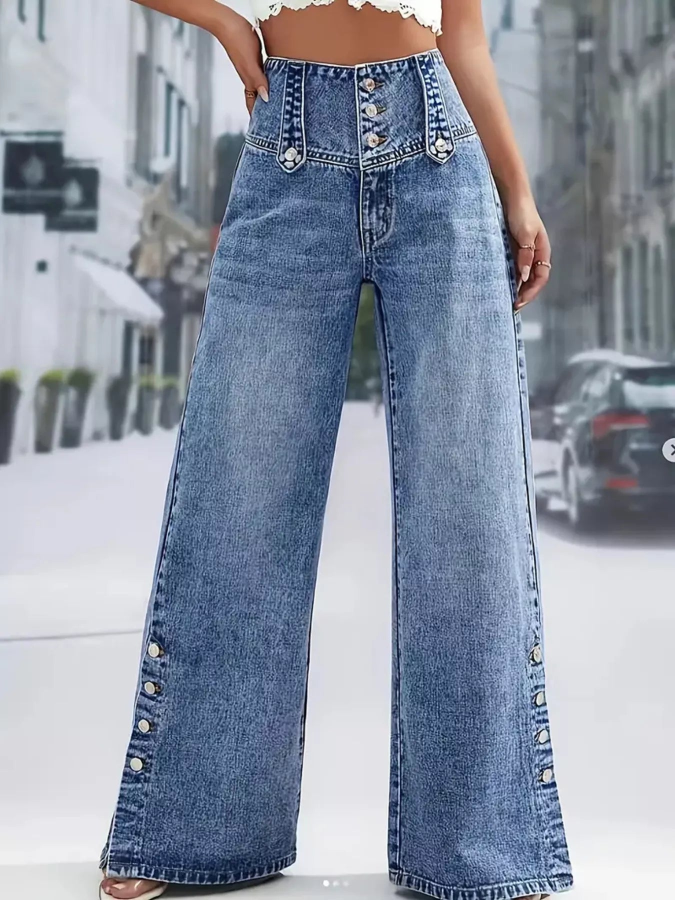 Wide-leg jeans with decorative buttons on a blurred city street background