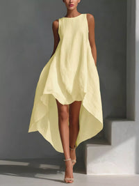 Woman wearing a light yellow dress against a gray background