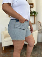 Person wearing light blue denim shorts in a casual indoor setting