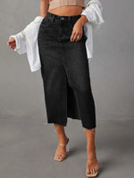 Person wearing black wide-leg jeans with a plain background