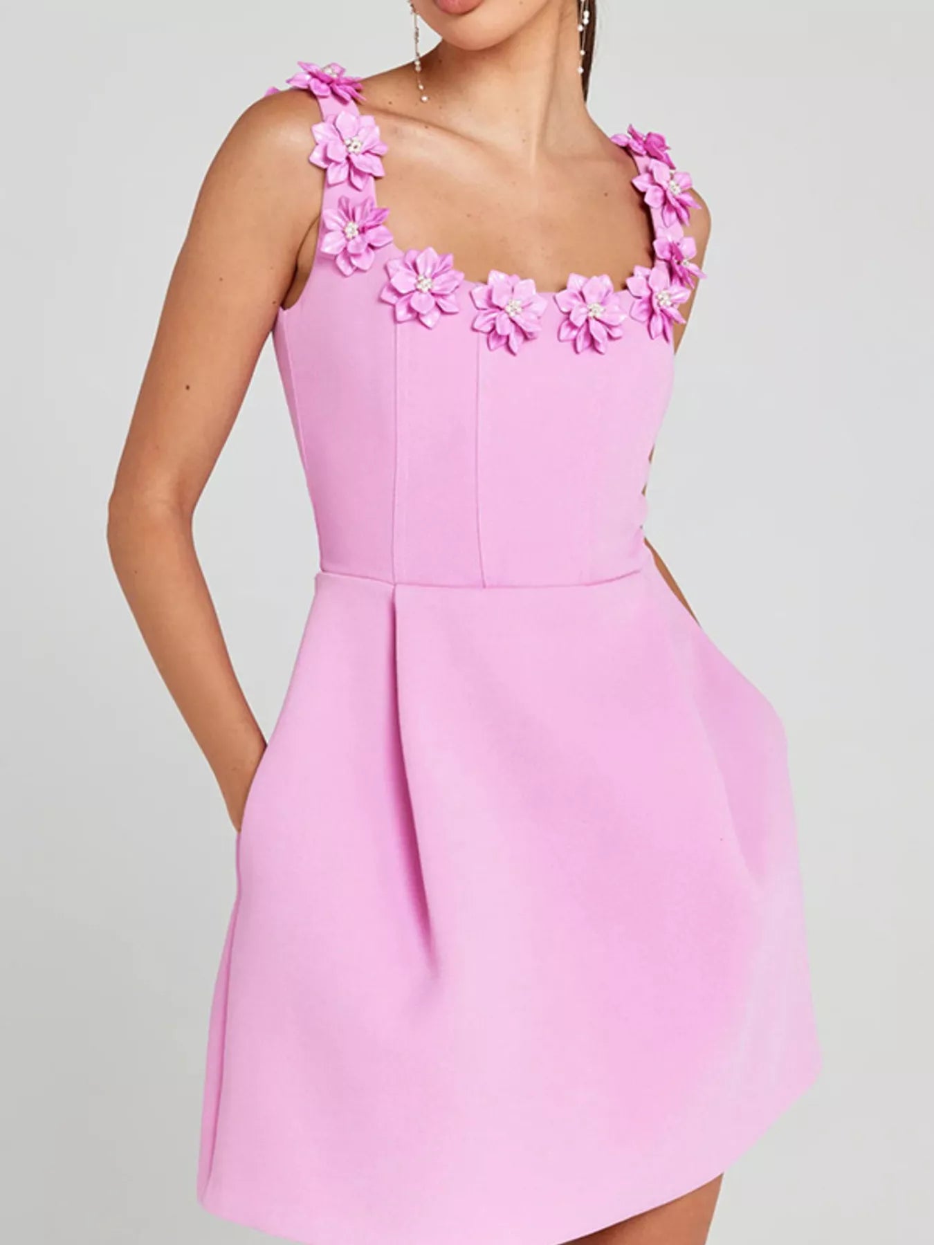 Pink dress with floral straps on a gray background