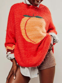 Person wearing a red sweater with a pumpkin design on a plain background