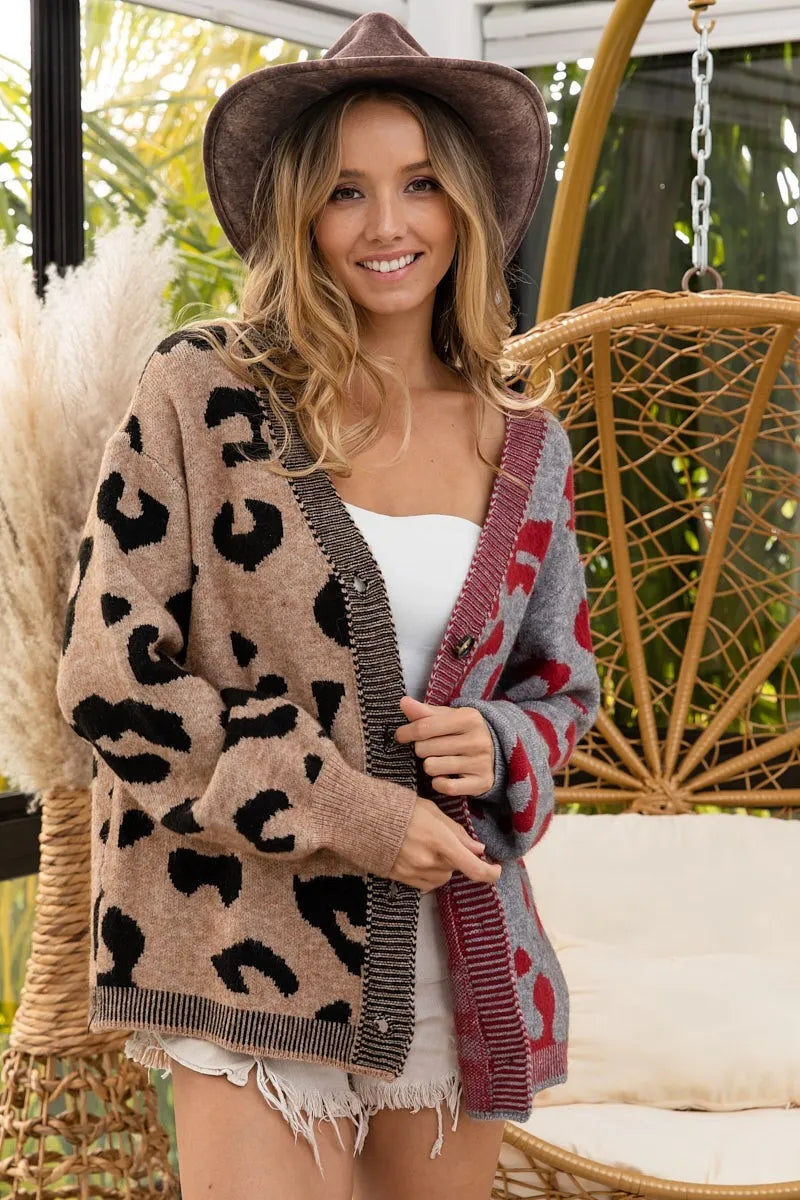 Woman wearing a leopard print cardigan over a white top, sitting on a wicker chair.