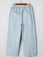Light blue striped pants on a hanger against a white background