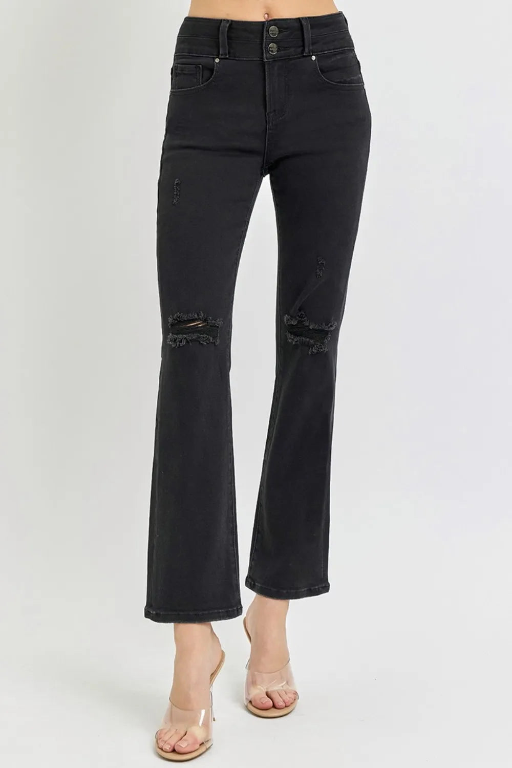 Black jeans with distressed details on a white background