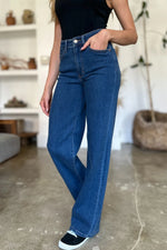 Person wearing blue jeans and a black top in an indoor setting