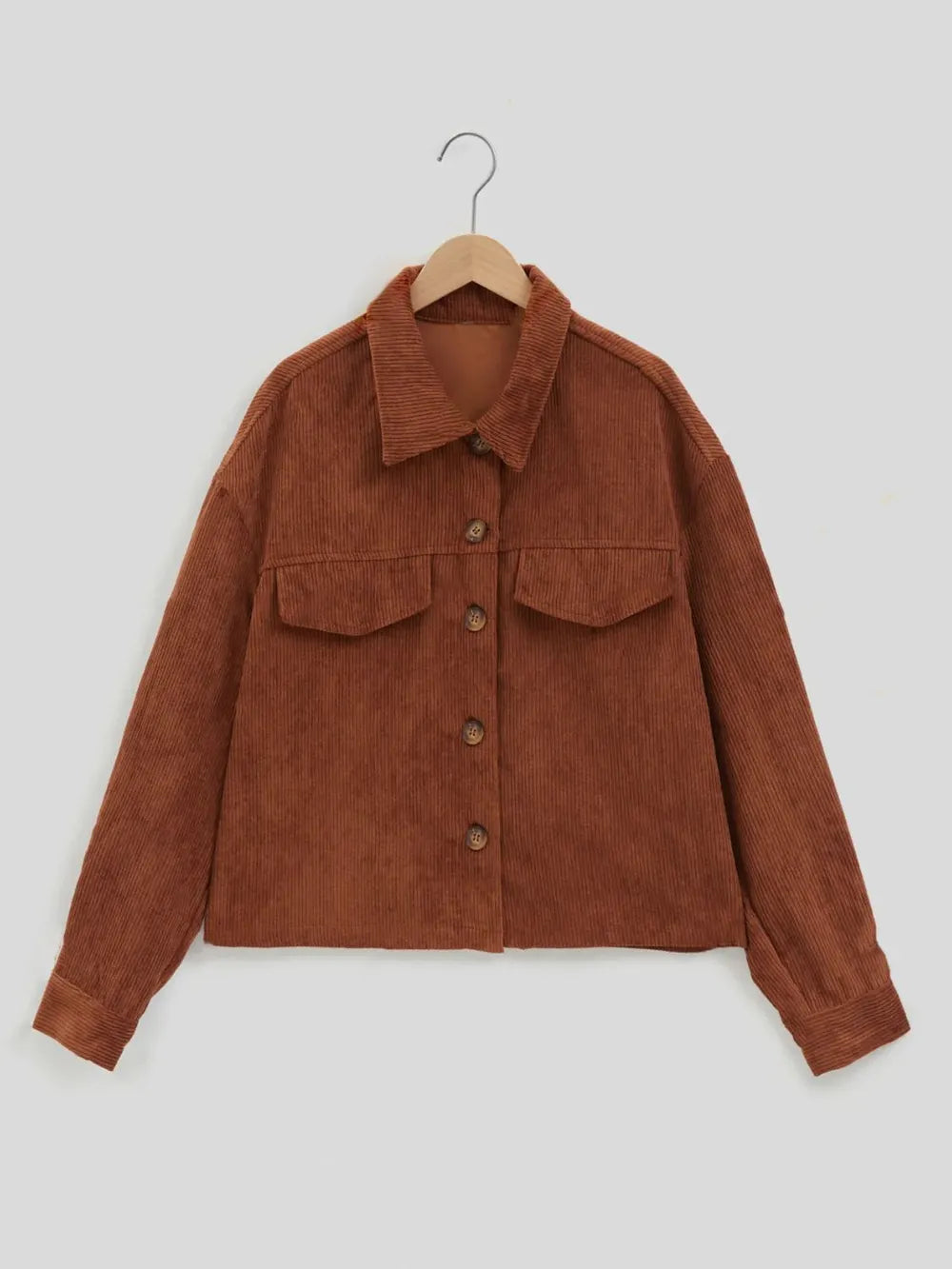 Brown corduroy jacket on a hanger against a white background