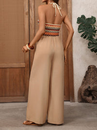 Woman wearing a beige jumpsuit with an open back in a casual setting.