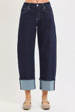 Dark blue jeans with cuffed hems on a white background