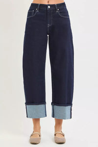 Dark blue jeans with cuffed hems on a white background