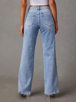 Light blue jeans worn by a person on a gray background