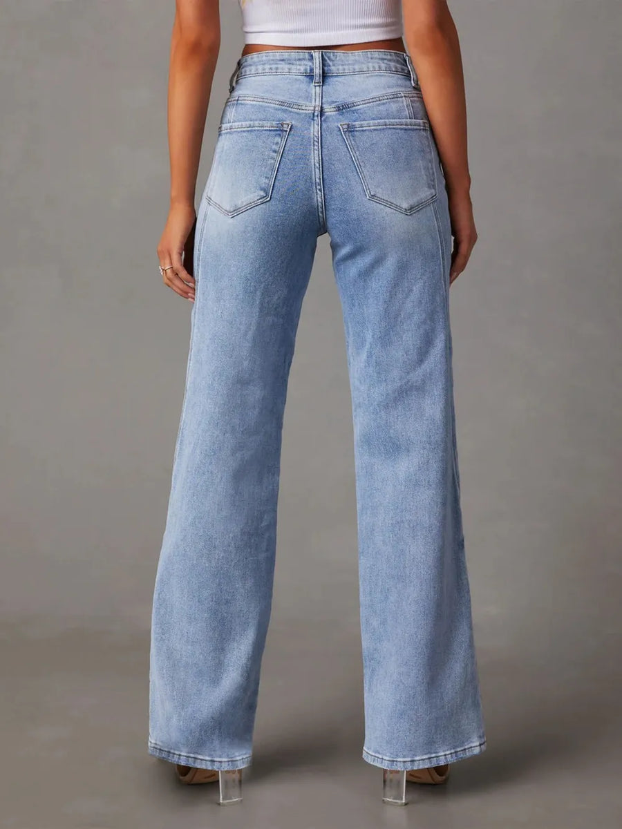 Light blue jeans worn by a person on a gray background