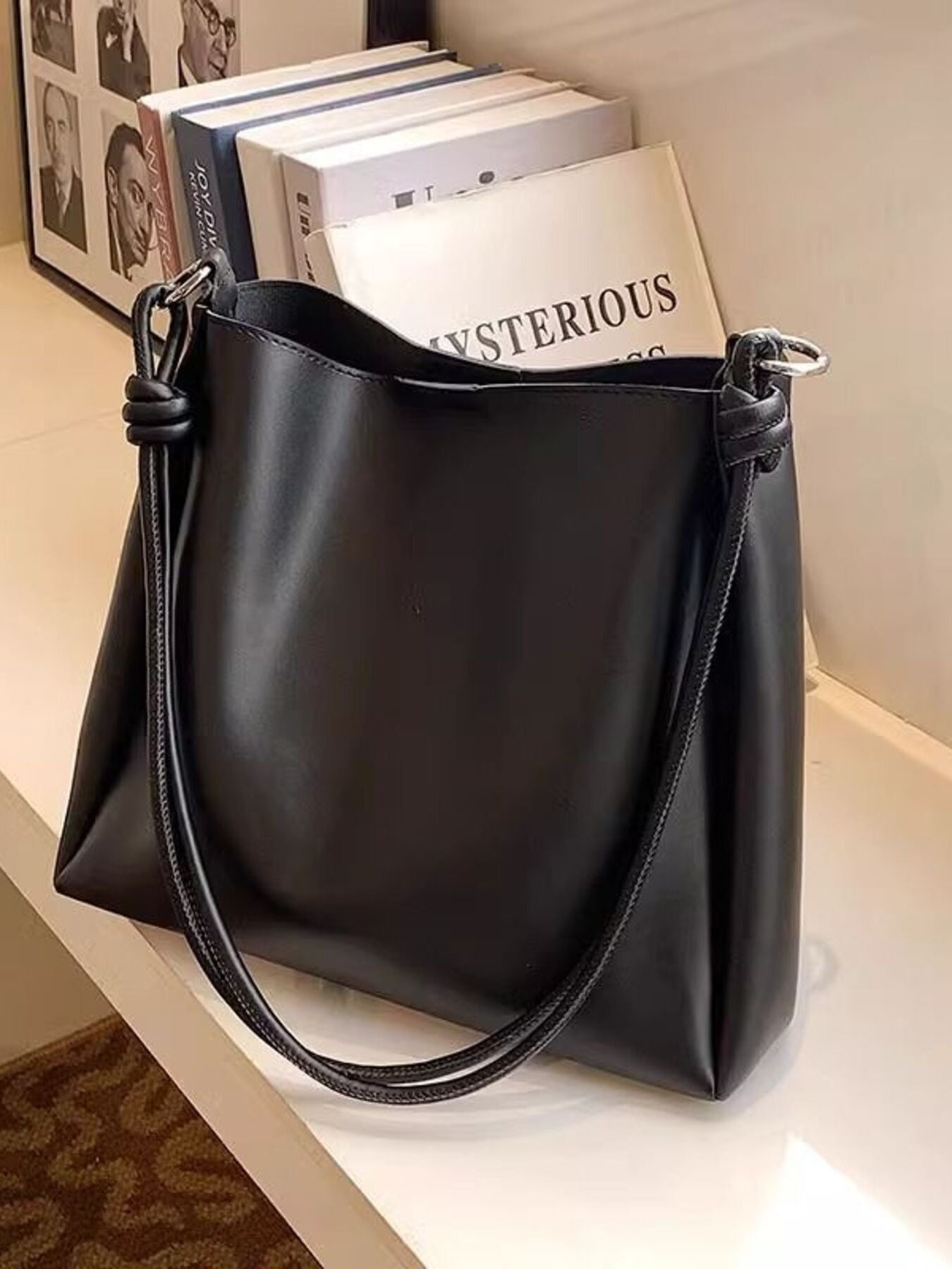 Black handbag with a handle on a light surface