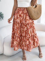 Person wearing a floral skirt and holding a straw bag indoors.