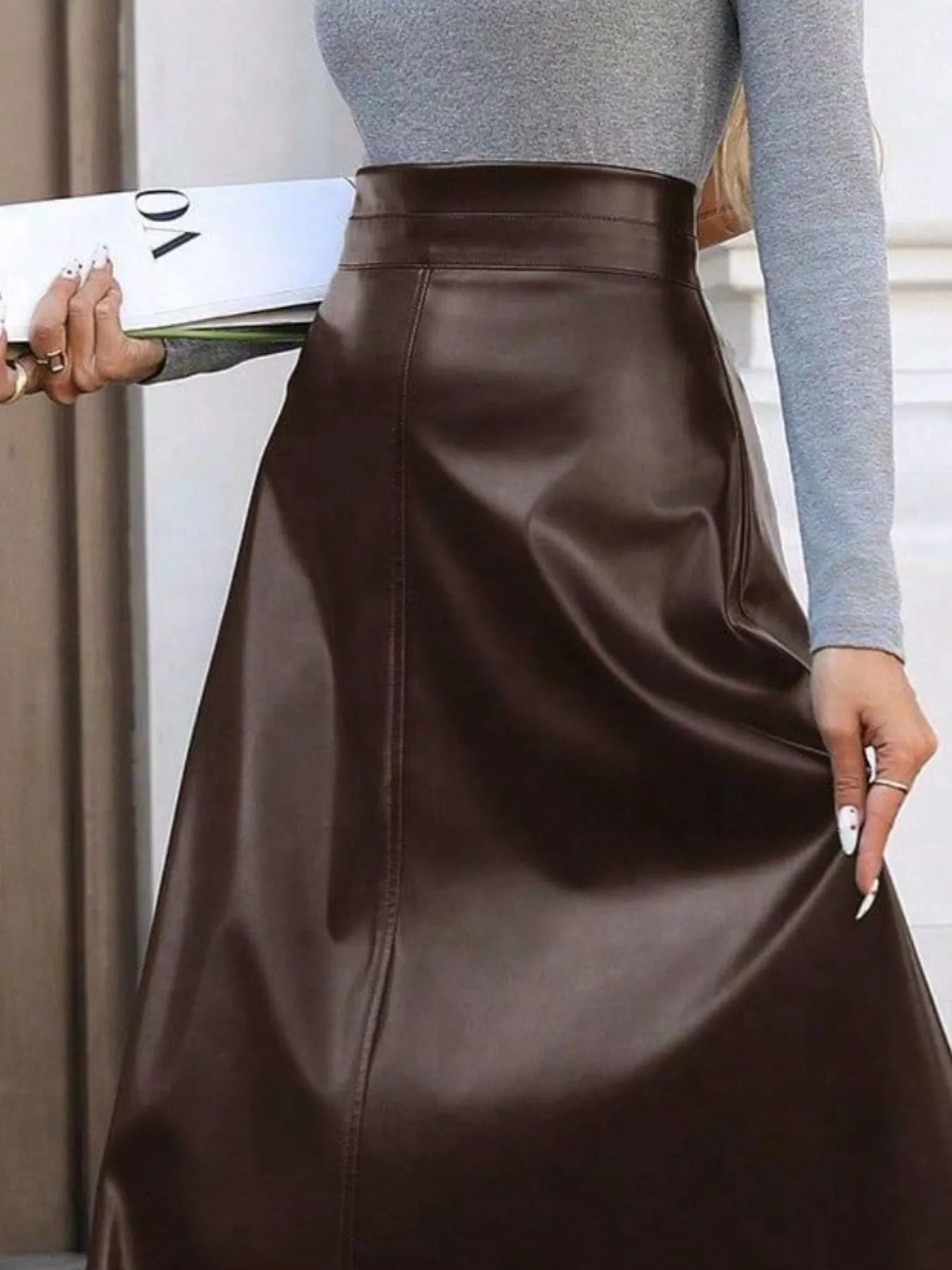 Brown leather skirt worn by a person with a neutral background