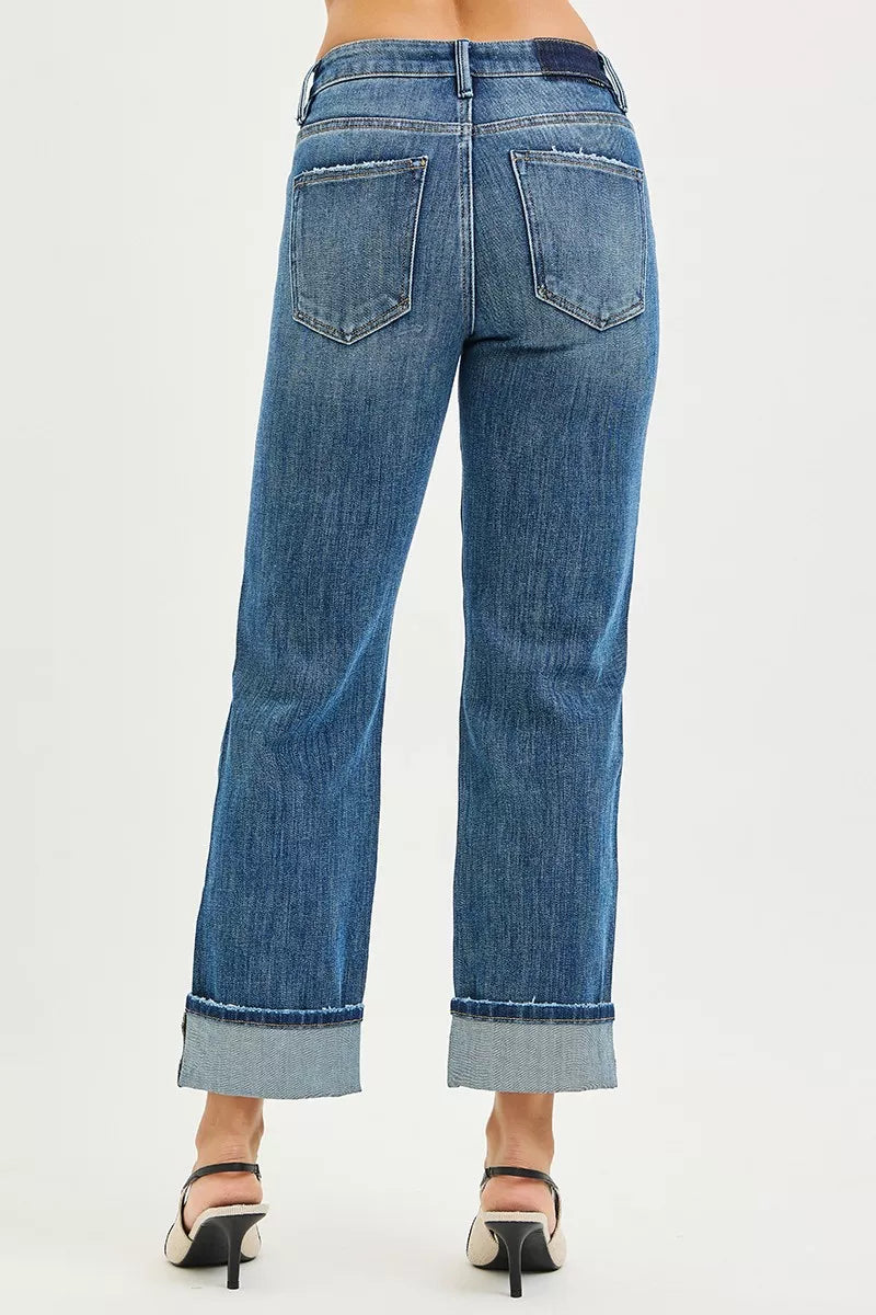 Blue jeans with a cuffed hem on a white background