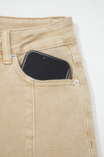 Phone in a pocket of beige pants on a white background
