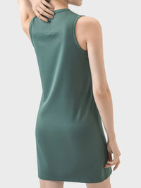 Green sleeveless dress worn by a person on a light gray background