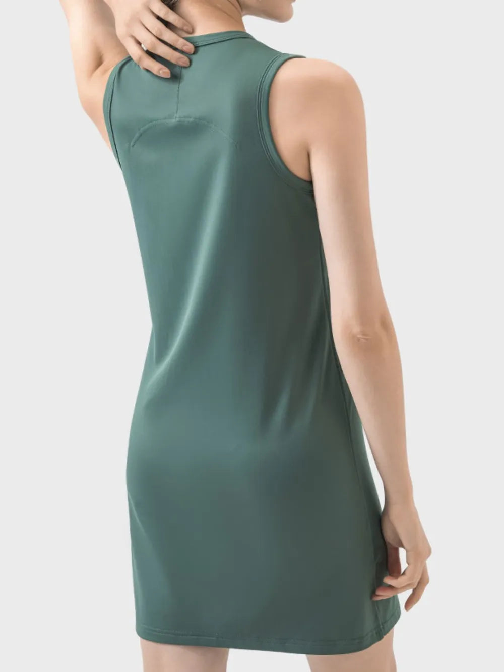 Green sleeveless dress worn by a person on a light gray background