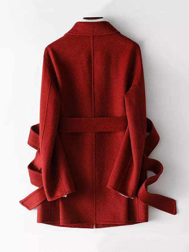 A red wrap-style coat with wide sleeves and matching waist ties, shown from the back on a white mannequin against a plain white background.