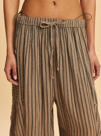 Striped pants with a drawstring waist on a beige background