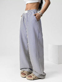 Person wearing black and white striped pants on a white background