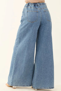 Blue wide-leg jeans on a plain background