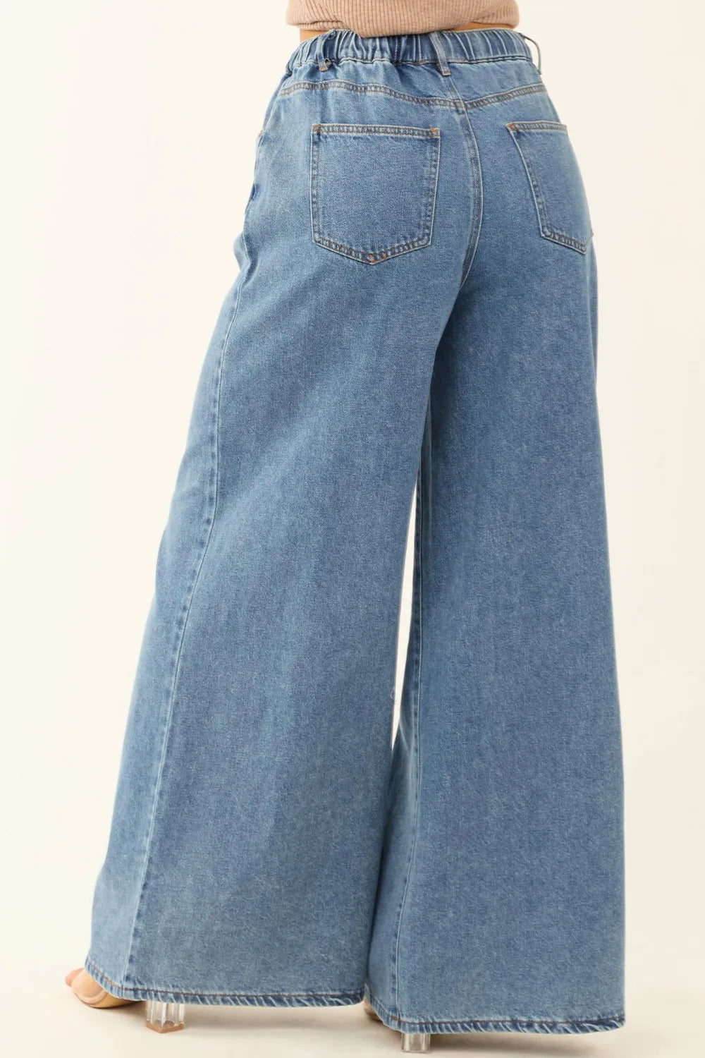 Blue wide-leg jeans on a plain background