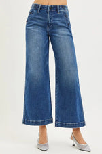 Blue wide-leg jeans worn by a person on a white background