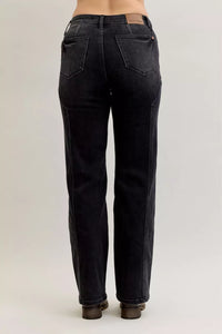 Black jeans worn by a person on a plain background