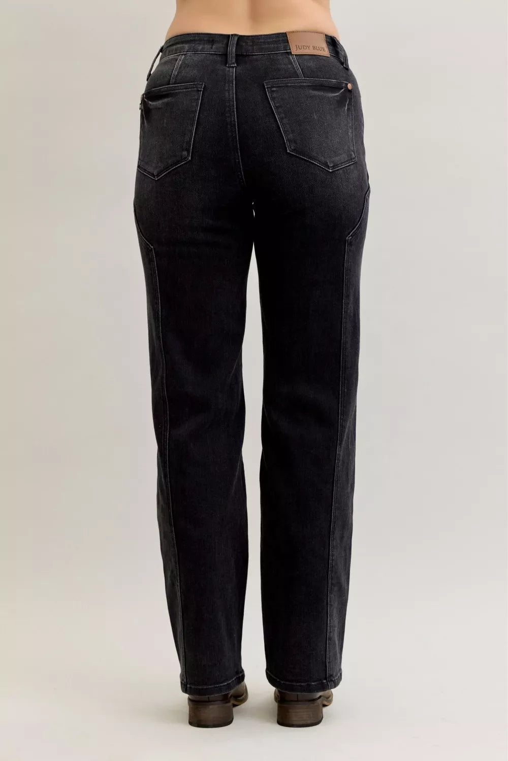 Black jeans worn by a person on a plain background