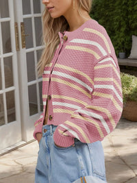 Woman wearing a pink and yellow striped sweater outdoors.