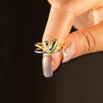 Heart-shaped ring on a finger against a dark background