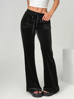 Maroon velvet pants worn by a person on a white background