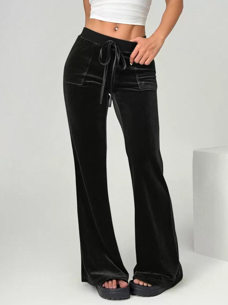 Maroon velvet pants worn by a person on a white background