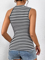 Person wearing a black and white striped tank top against a white background