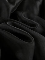Close-up of dark fabric with folds on a black background