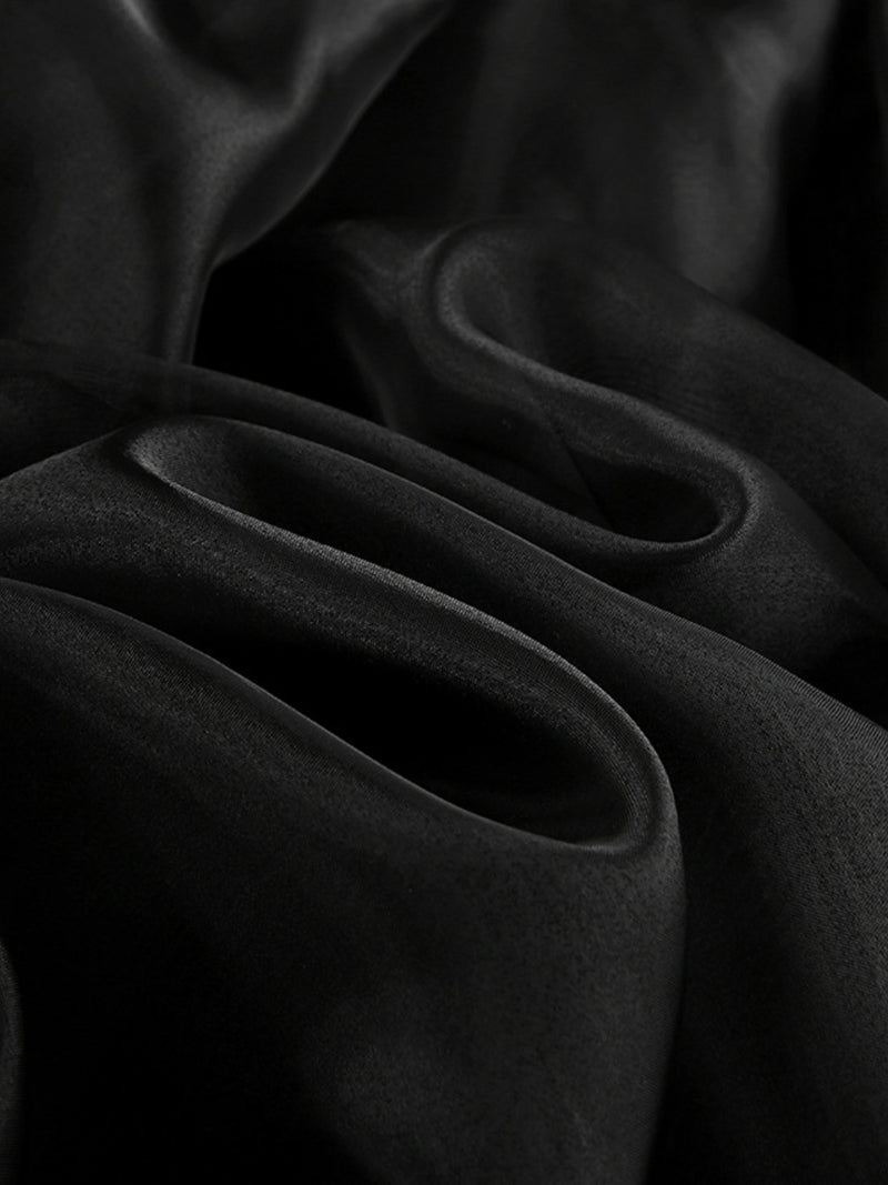 Close-up of dark fabric with folds on a black background