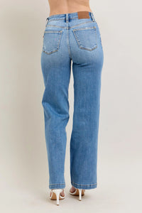 Blue jeans worn by a person on a plain background