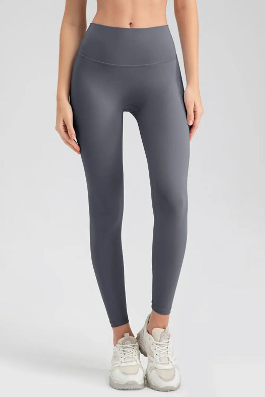 Person wearing gray leggings on a white background