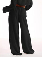 Black wide-leg pants with a brown belt on a white background