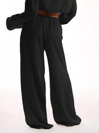 Black wide-leg pants with a brown belt on a white background